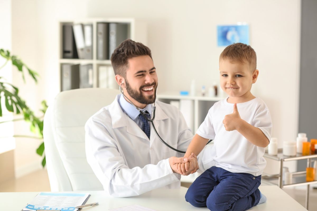 Un pediatra examina a un simpático niño en una clínica médica