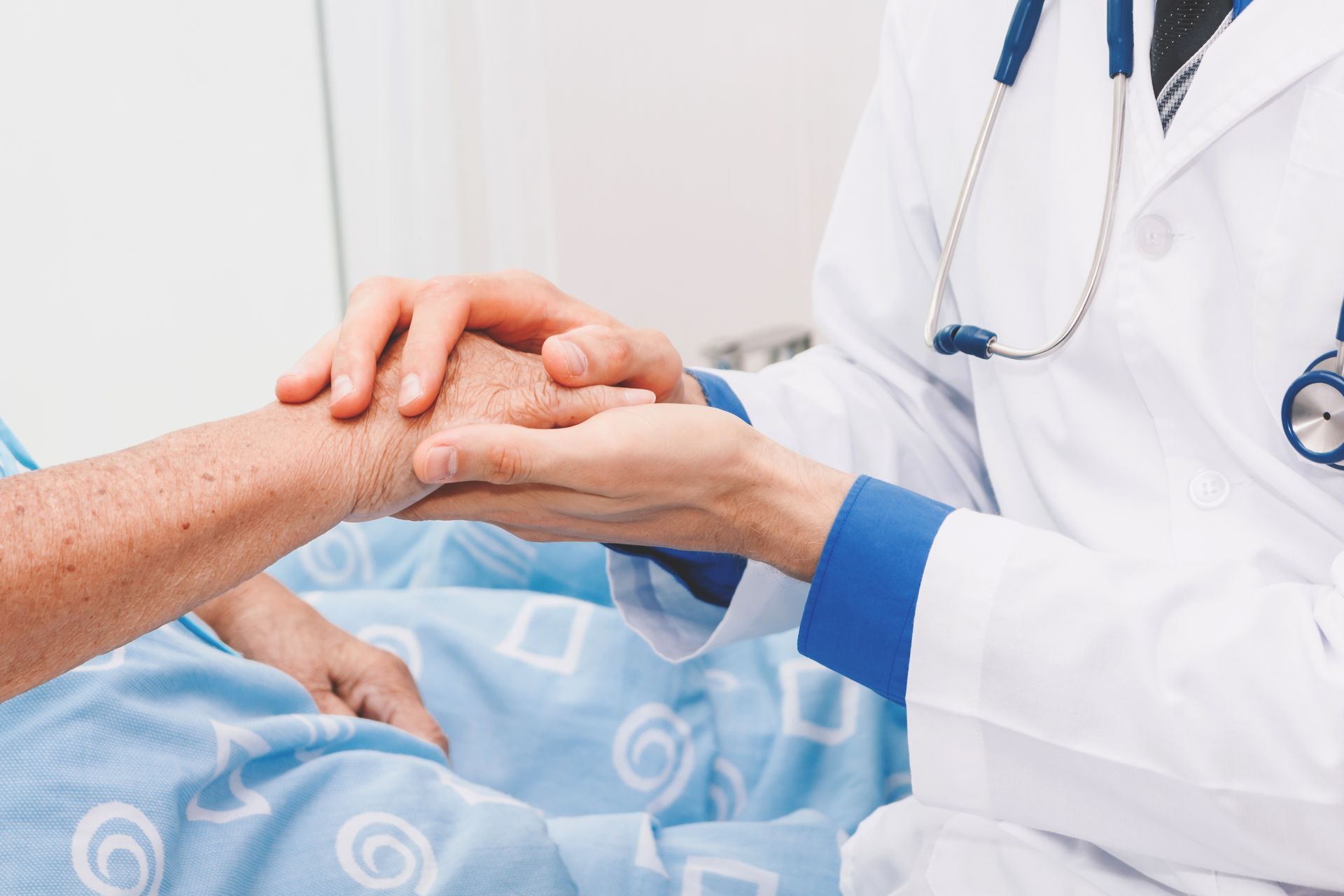 Doctor que sostiene la mano de una persona mayor con cuidado en el hospital. Salud y medicina